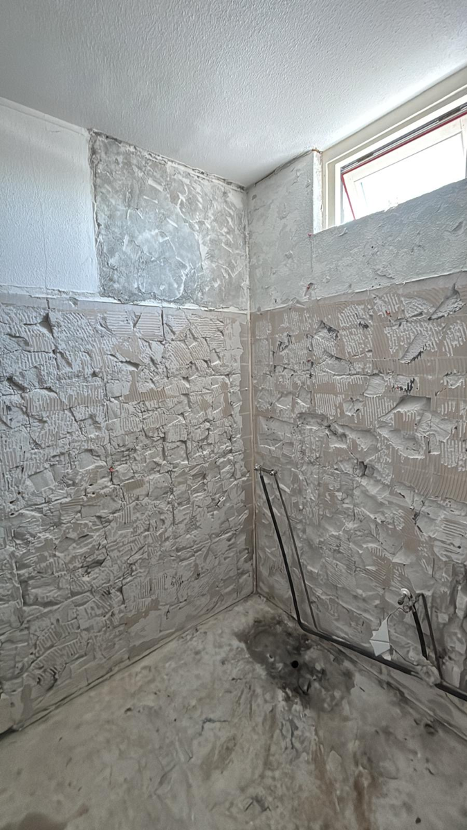 Badkamer gestript tot op de muur, zonder tegels en sanitair
